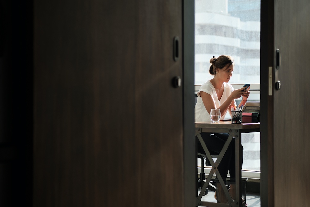 Woman Working In Corporate Office Sending Email With Phone - Topic Power